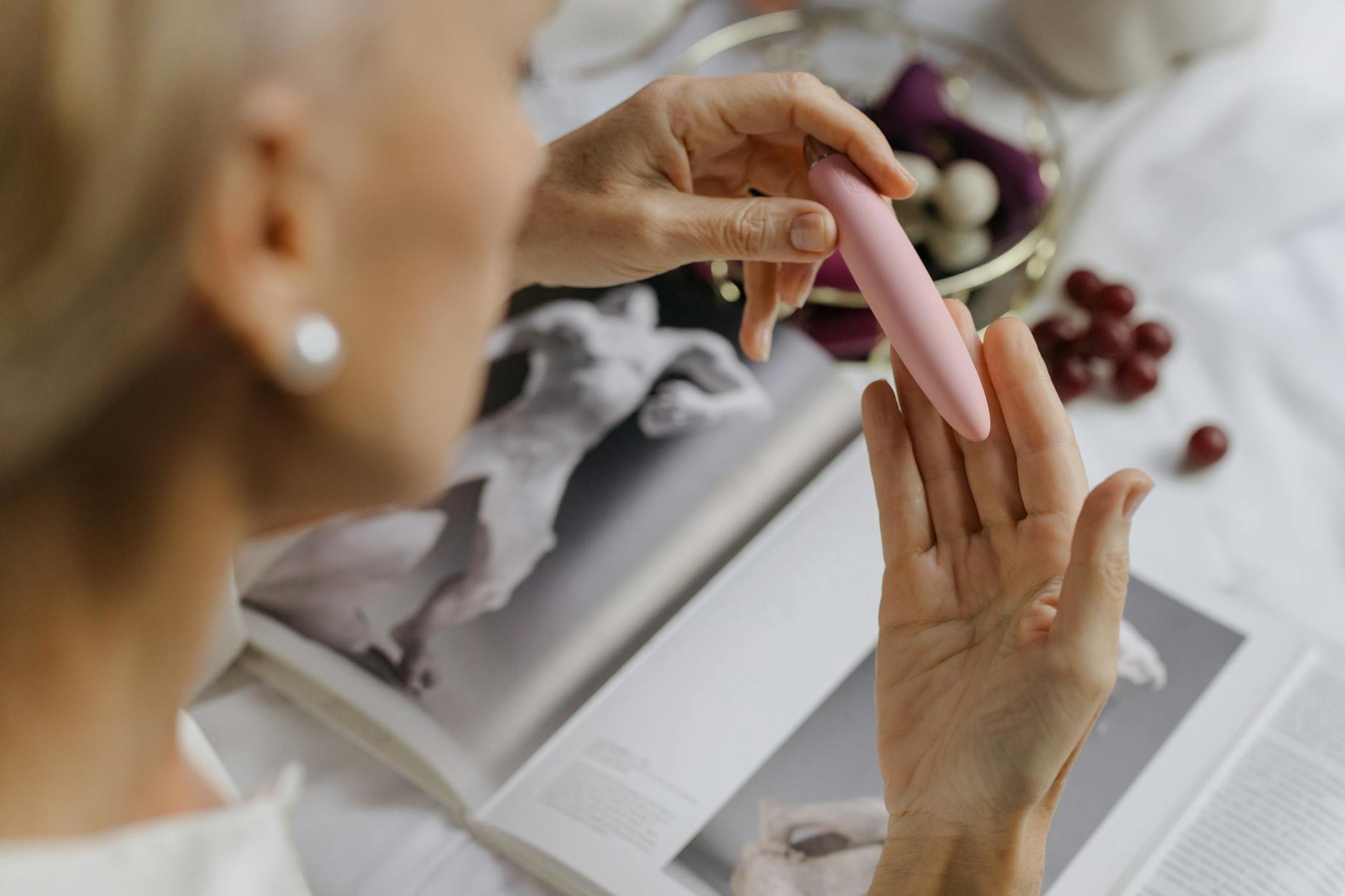 Woman holding a blue and pink silicone vibrator, exploring pleasure during hormonal transitions