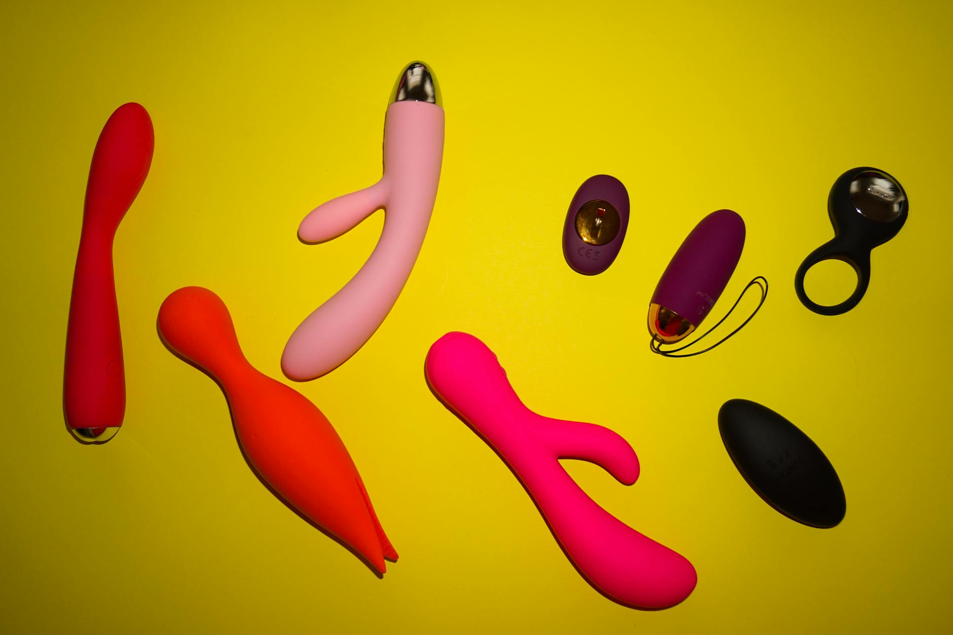 Vibrant collection of various clitoral vibrators arranged on a bright surface