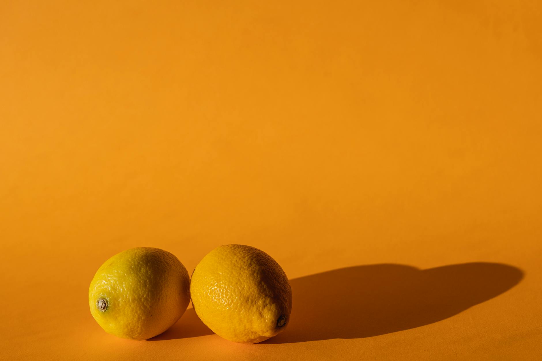 Ripe lemons on a bright yellow background, symbolizing renewed sensitivity